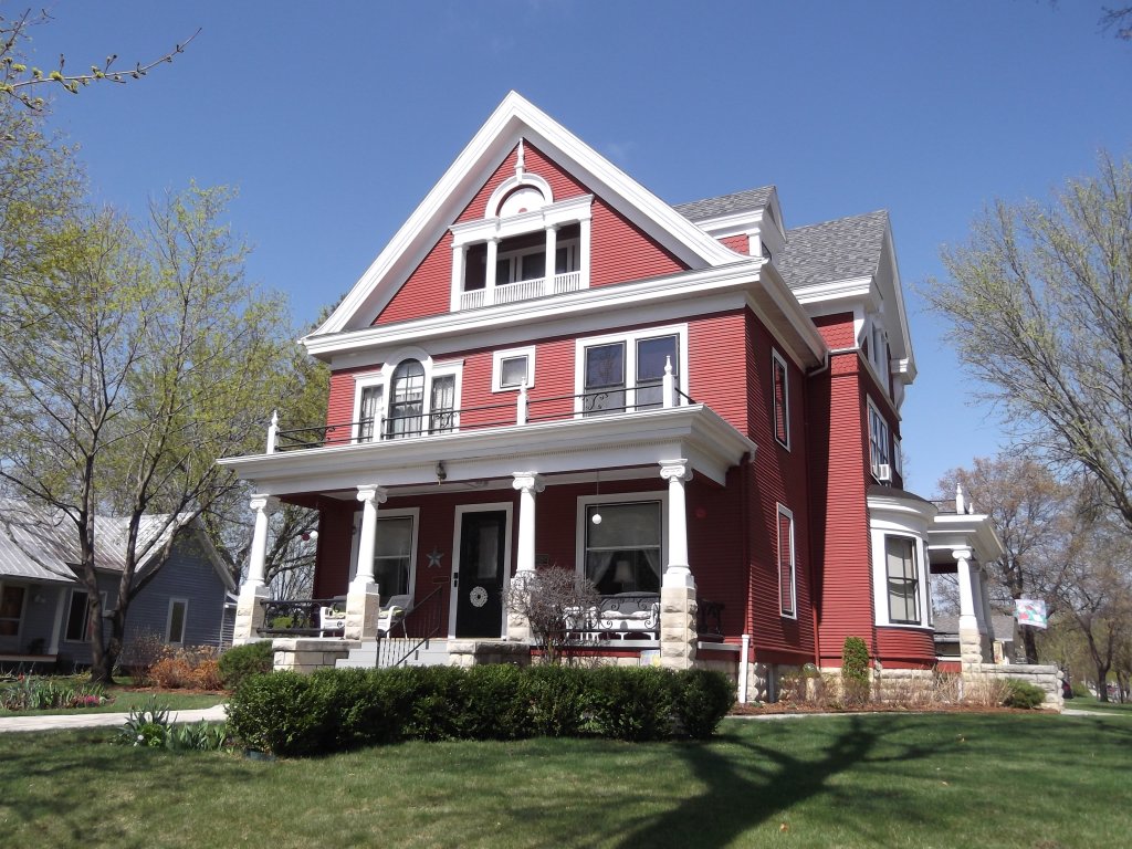A red victorian house with white accent trim