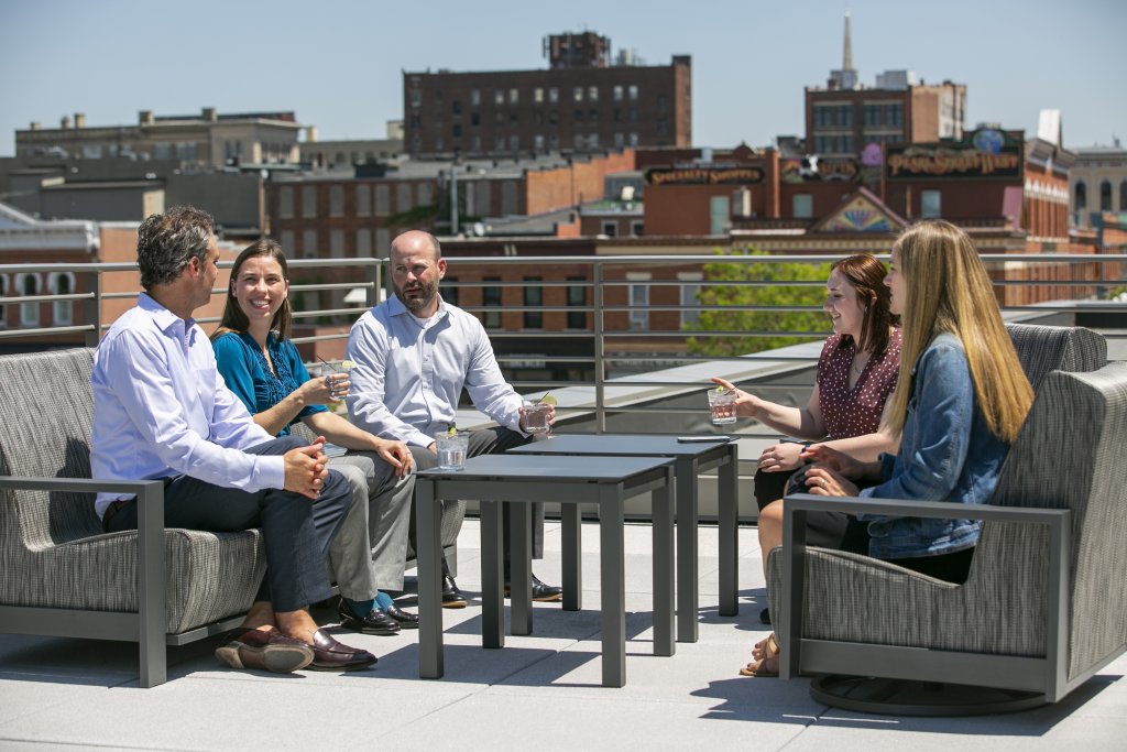 a group of people having drinks on a rooftop