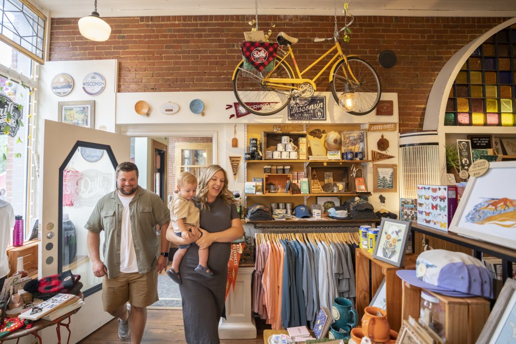 a family with a mother holding their toddler in a clothing store