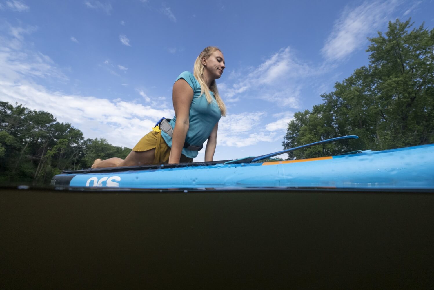 stand up paddle board with a lady doing yoga on the water