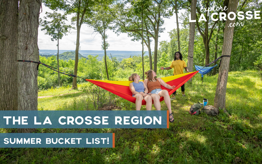 two people sharing a hammock and a person standing behind them in the woods
