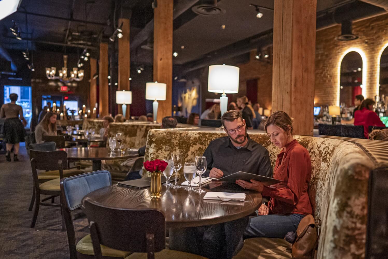 A couple looking at a menu at a romantic restaurant