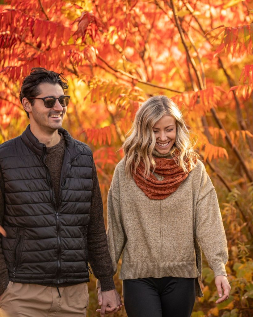 A couple smiles while holding hands during a stunning fall hike in beautiful La Crosse, Wisconsin.