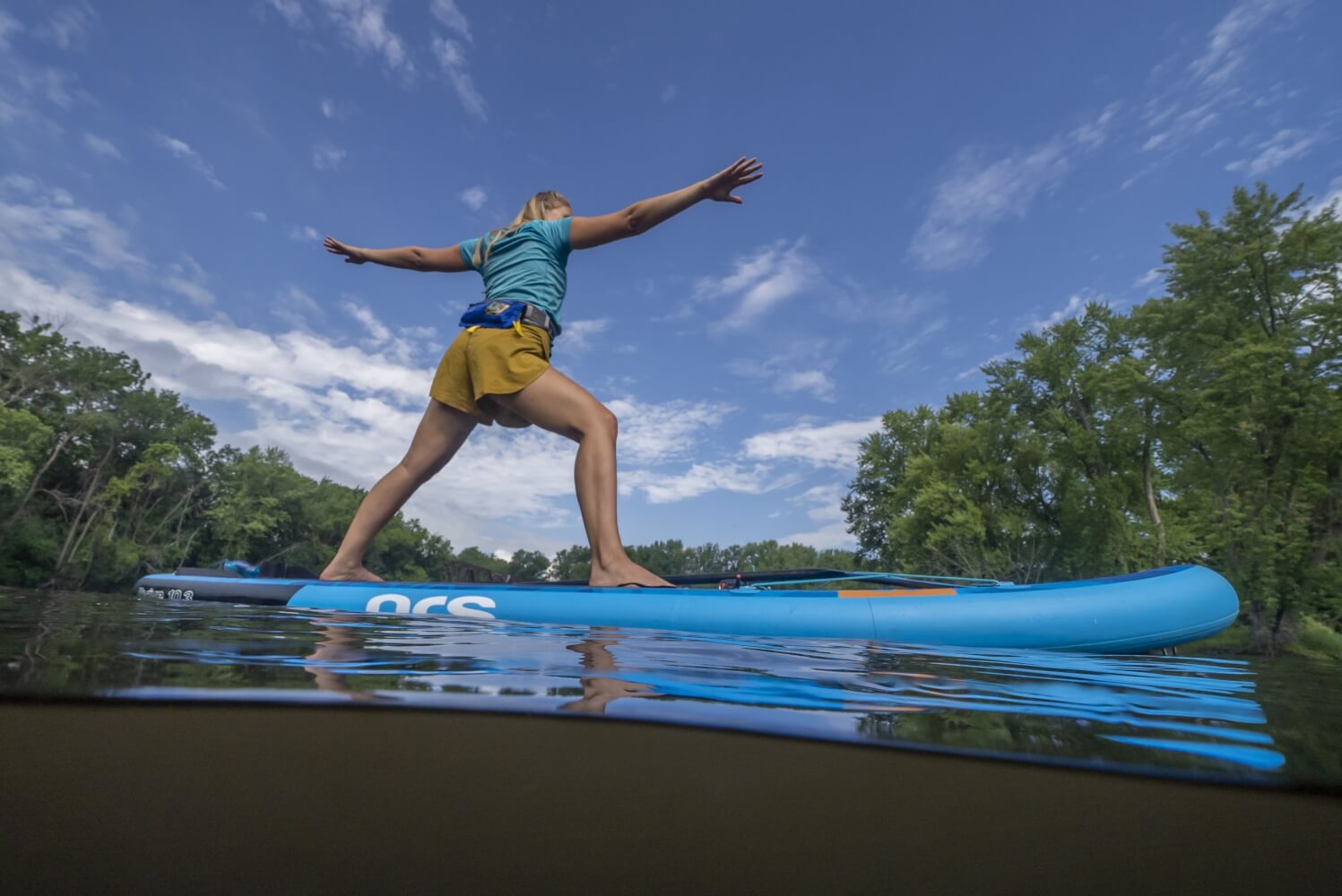 a woman on a paddle board doing yoga on the water in the La Crosse Region