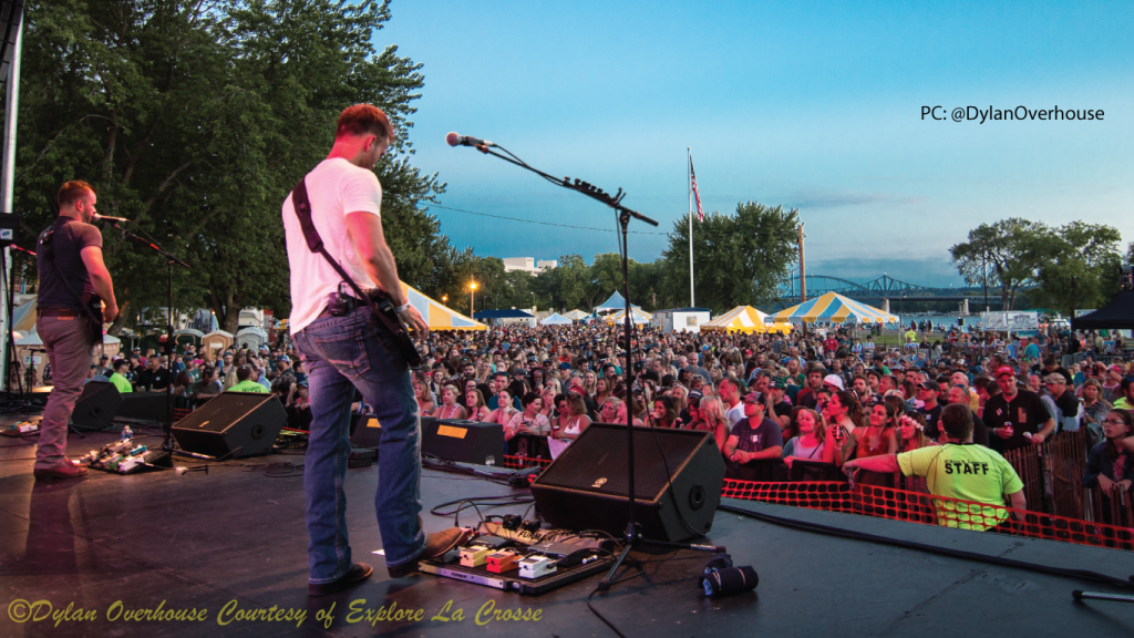 A person performing in front of a crowd during a summer festival
