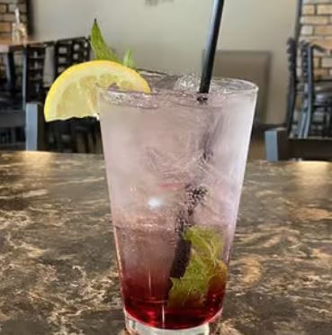 a glass of liquid with a straw and a slice of lemon