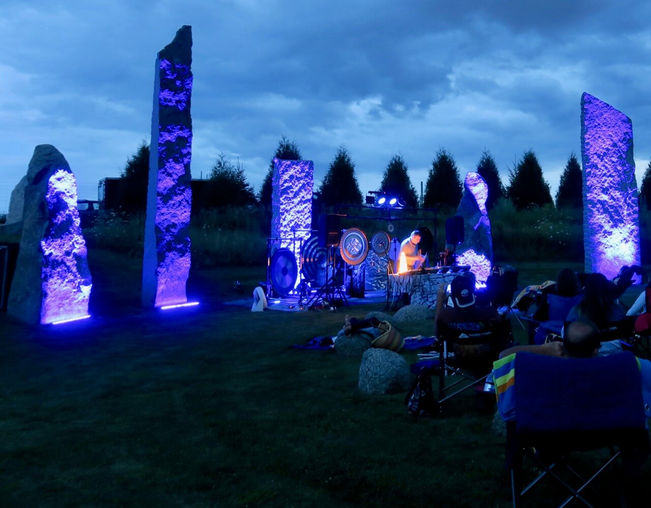 a group of people sitting in chairs outside with a stage set
