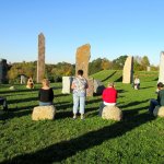 a group of people sitting on rocks in a field