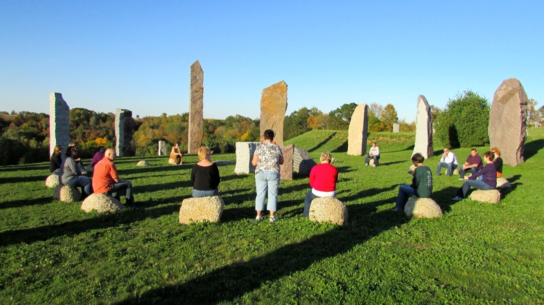 a group of people sitting on rocks in a grassy area