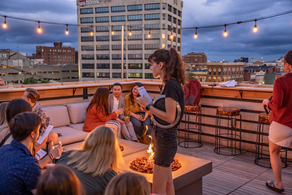 People chat in small groups on a rooftop bar with a firepit in beautiful La Crosse, Wisconsin.