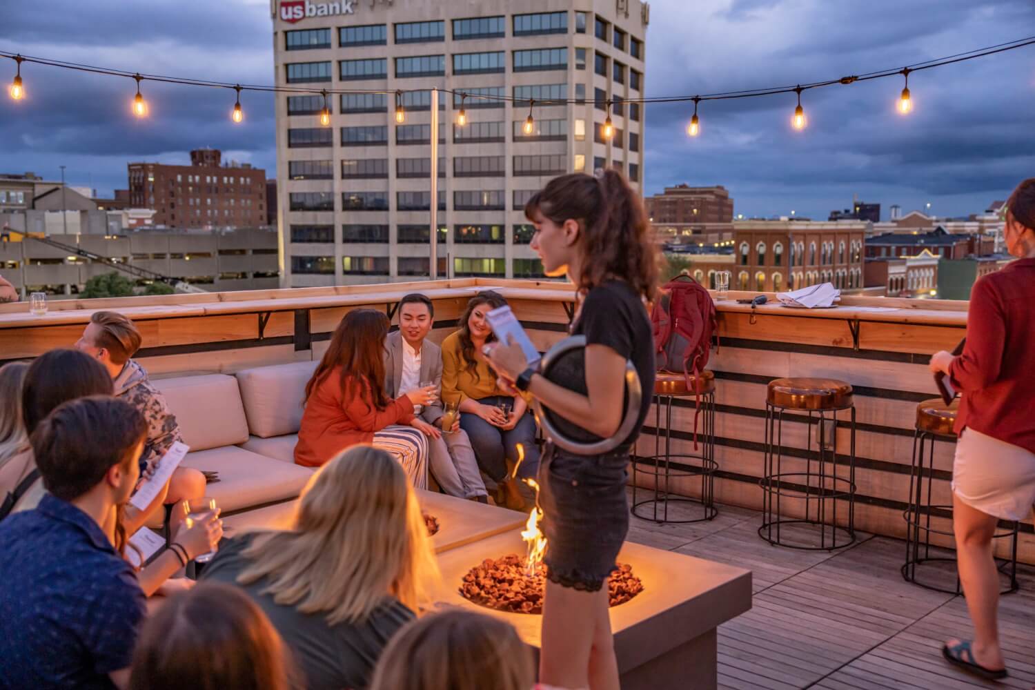 Signature Events 2 People chat in small groups on a rooftop bar with a firepit in beautiful La Crosse, Wisconsin.