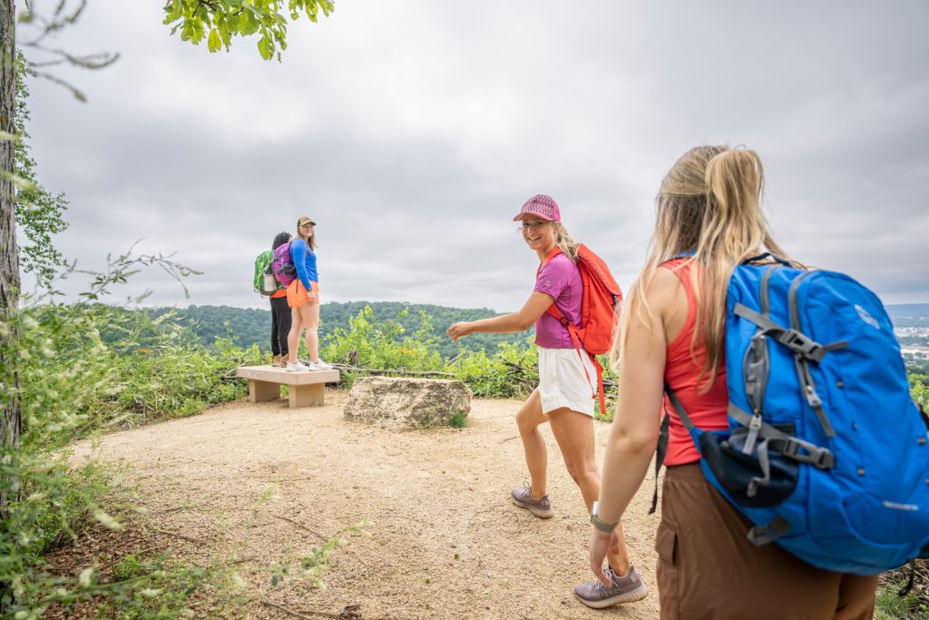 People smile as they approach an overlook during a scenic summer hike in La Crosse, Wisconsin.
