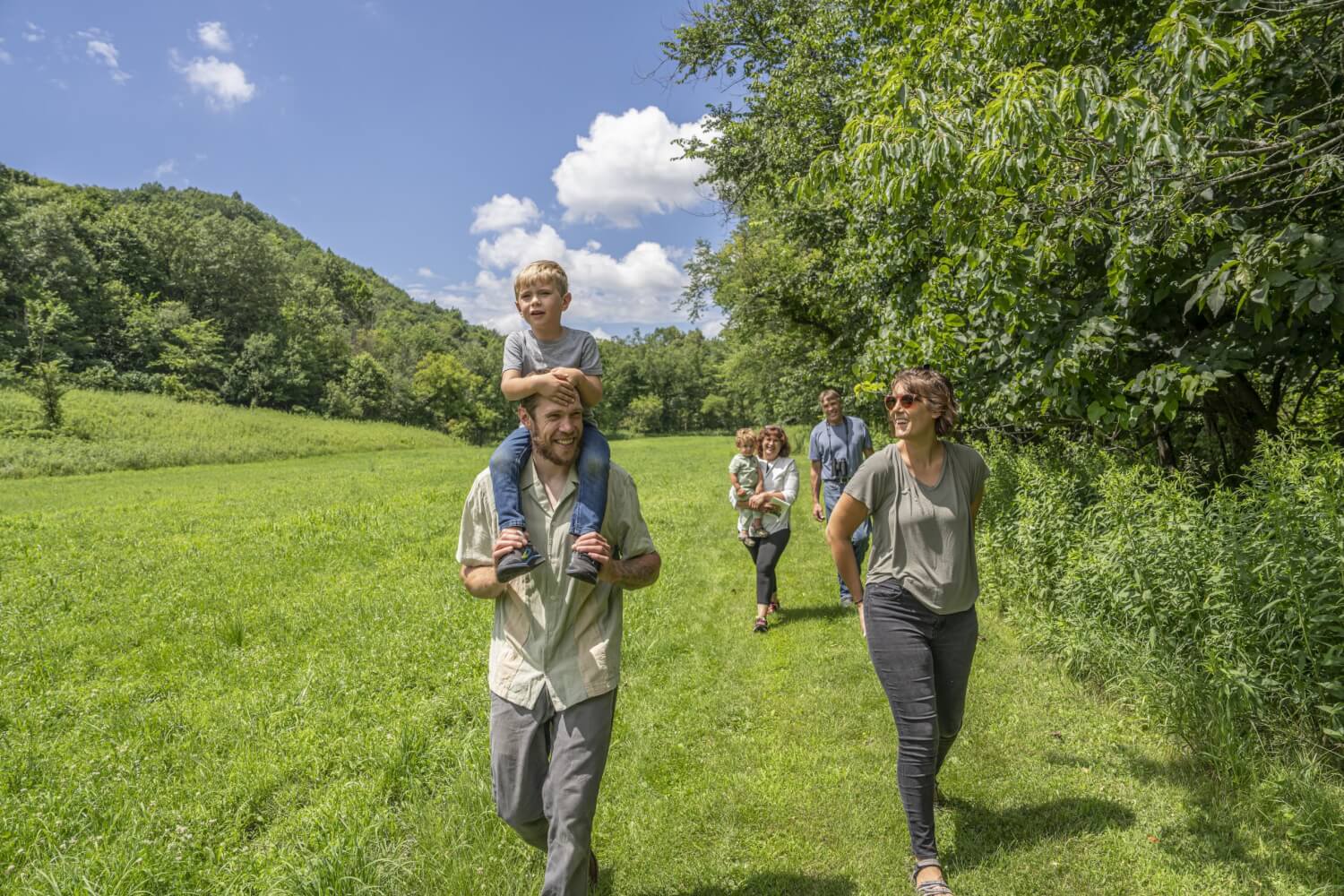 a group of people walking in a grassy area