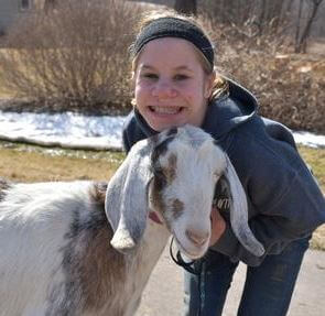 a woman holding a goat