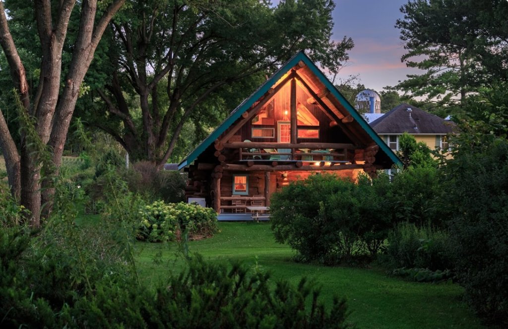 a house with a triangular roof and a green lawn