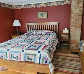 a bed with a blanket and a lamp in a room