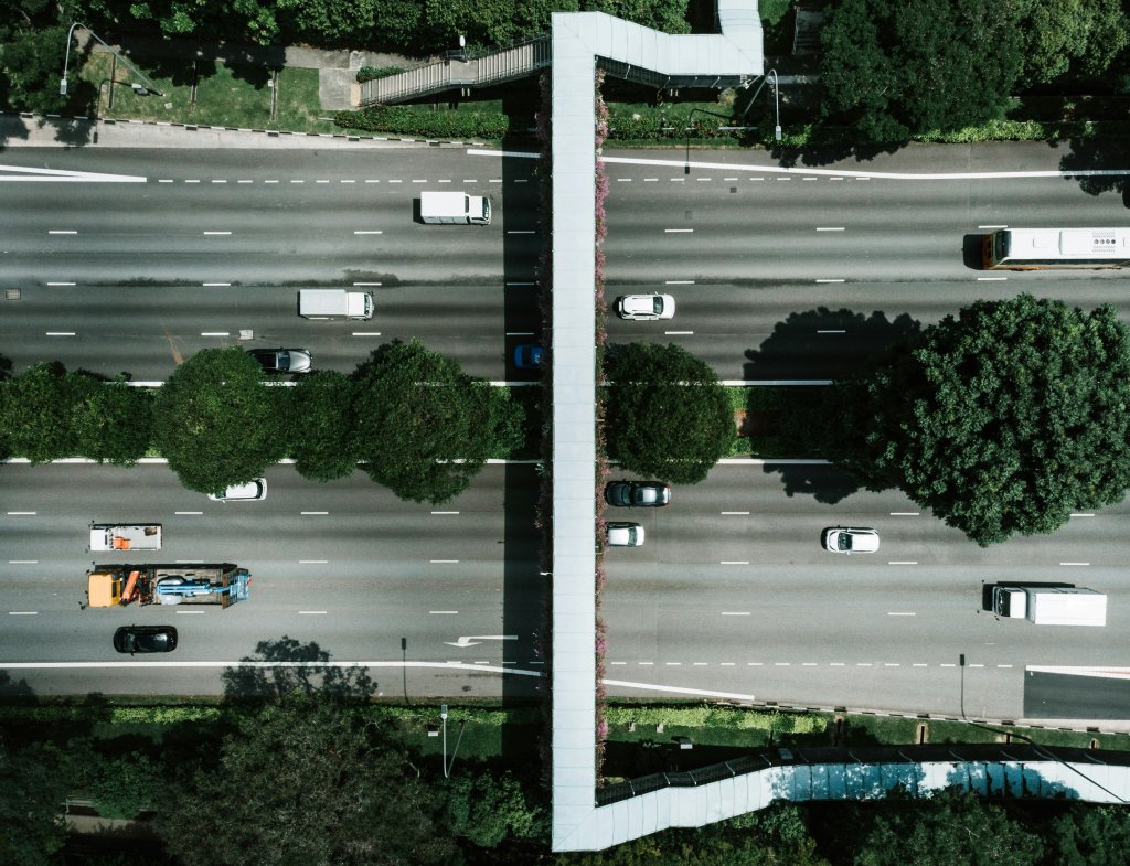 a highway with a few traveling cars is seen from an aerial view
