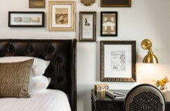 Hotel room in the Charmant Hotel featuring the bedside and beautiful frames hung next to the bed