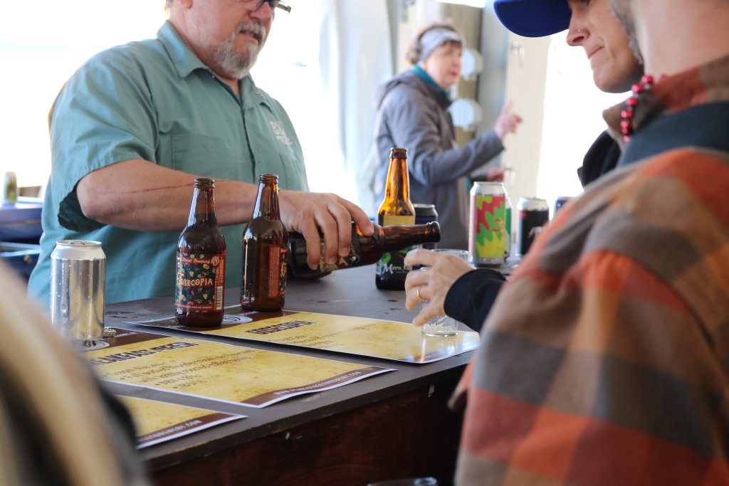A man pouring beer into a tasting glass in the VIP tent at Beer, Wine & Cheese Festival