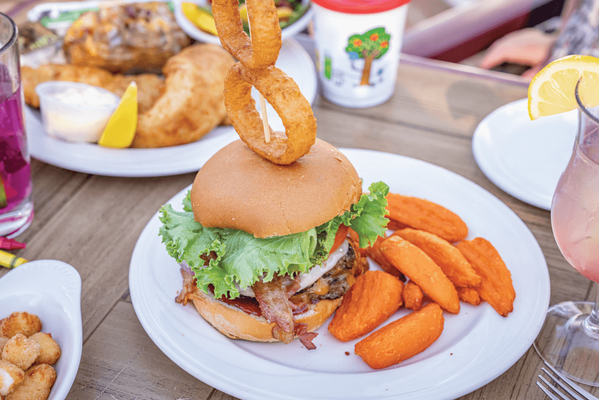 The Pool 8 burger at Huck Finn's on the patio in French Island and La Crosse Wisconsin during the summer months with refreshing beverages, fried fish and cheese curds enjoyed by a family.
