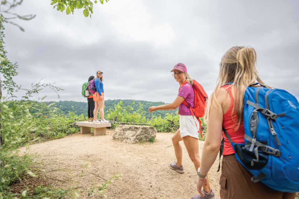 Group of friends hiking outdoors on 600-ft bluffs of the La Crosse Region of Wisconsin in the Summer including Grandad Bluff.