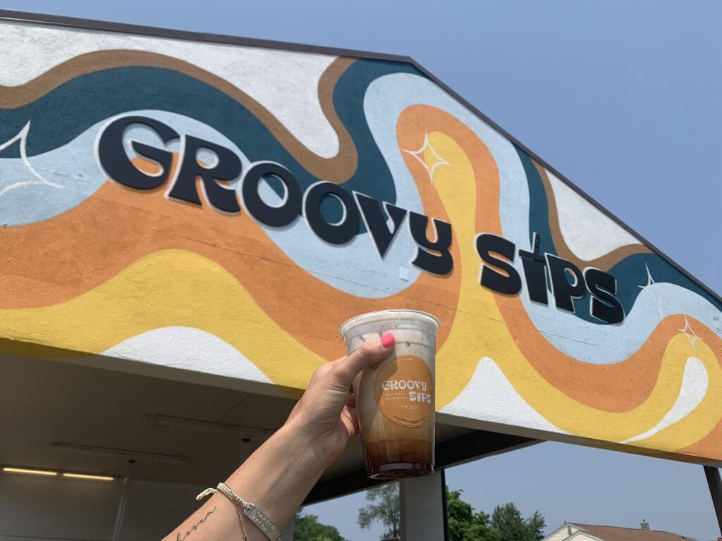Valentine's Sweepstakes 2025 7 a person holding a coffee in front of the groovy sips building