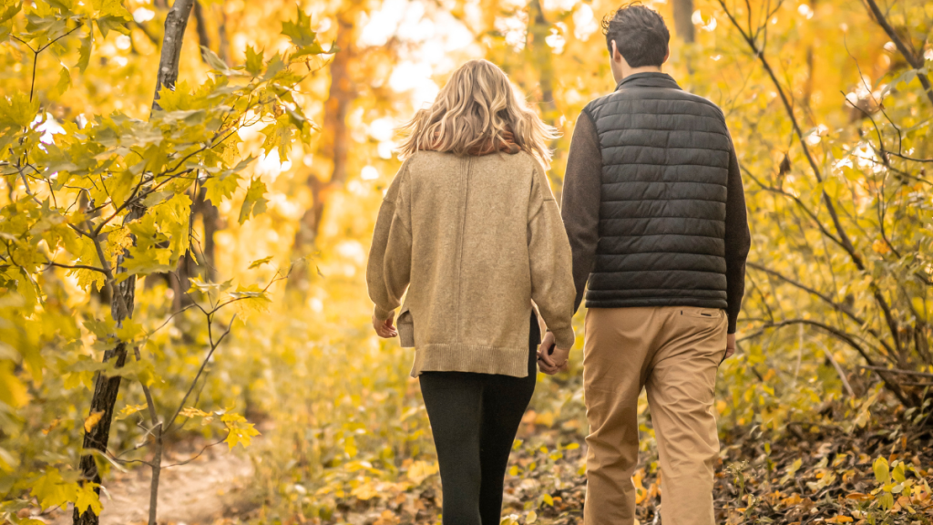 a couple hiking in fall foliage